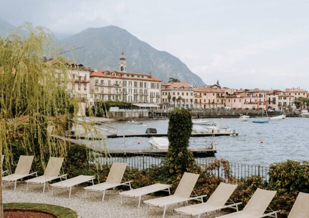A serene lakeside town with mountains and boats in Lombardy landscape