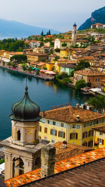 Historic tower and colorful houses by the lakeside in Lombardy region