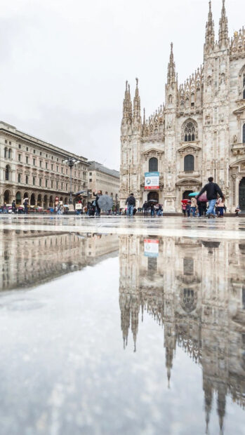 The Milan cathedral and square reflection after rain in Lombardy