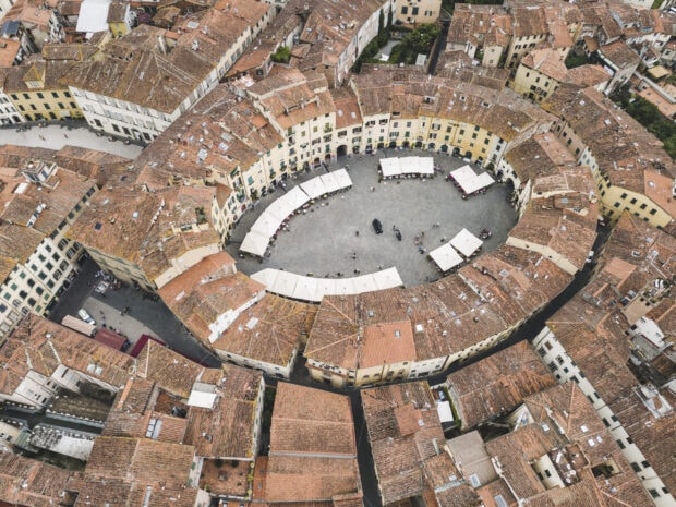 Aerial view of historic Lucca Italy with circular plaza surrounded by traditional buildings