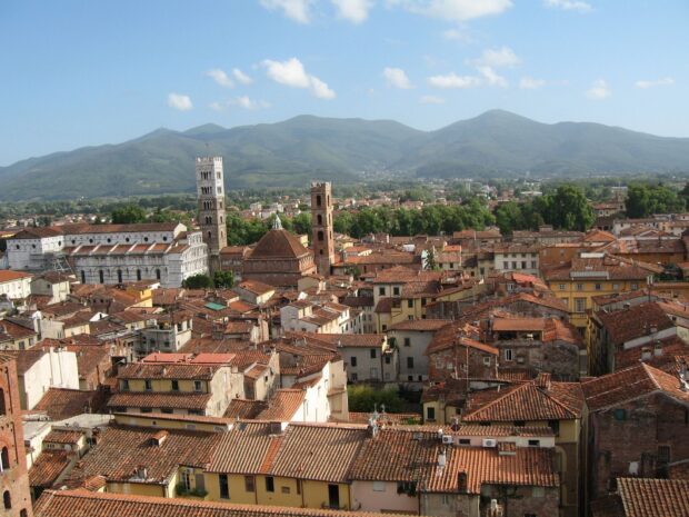 A panoramic view of Lucca Italy with historic buildings and hills in the background