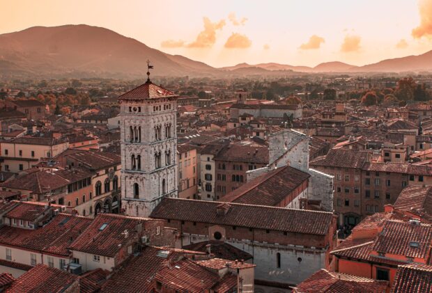 Historic architecture and old buildings in Lucca Italy at sunset with mountains in the background