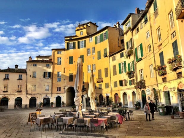 Historic buildings and empty outdoor seating in Lucca Italy vivid cityscape
