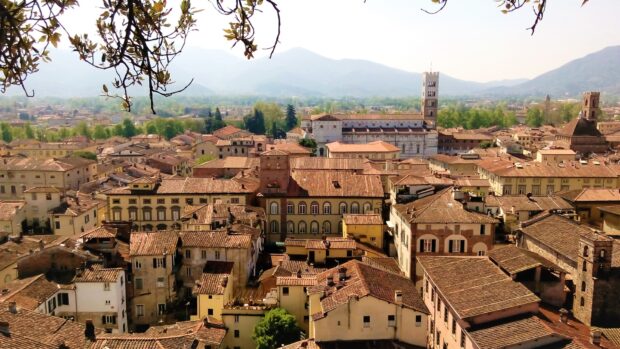 A panoramic view of Lucca Italy cityscape with historic buildings and mountains in the background