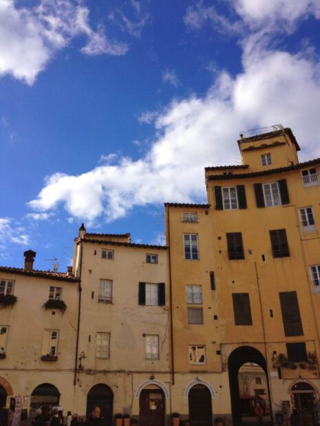 Historic buildings in Lucca Italy under a blue sky with clouds