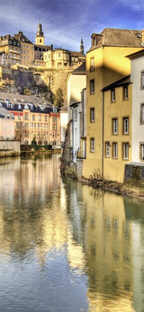 Beautiful Luxembourg cityscape with colorful historic buildings along the riverbank reflecting in the water