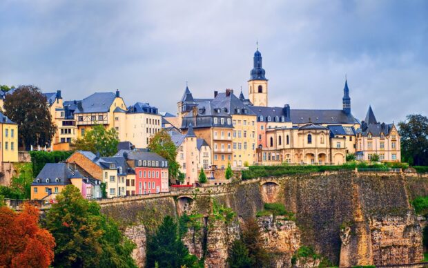 Historic architecture in Luxembourg surrounded by autumn trees and cliffs