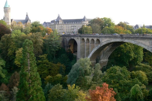 Old stone bridge over green forest in Luxembourg cityscape