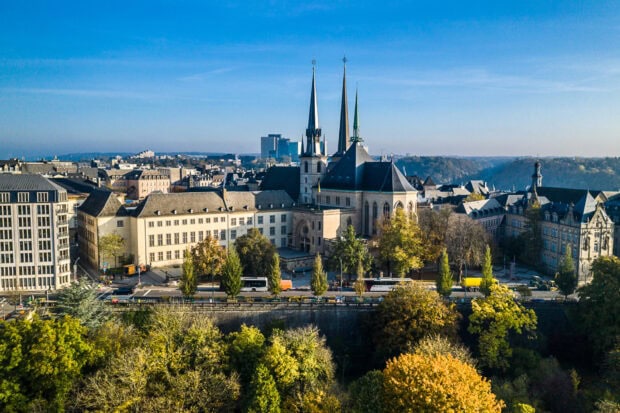 Historic architecture and cityscape of Luxembourg with autumn trees and blue sky