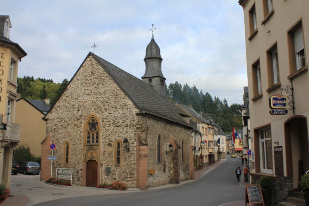 Historic church in Luxembourg town with old stone architecture and narrow street view