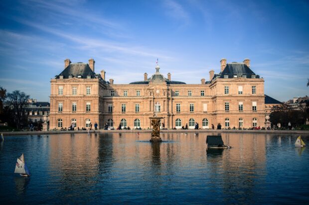 Historic Luxembourg building reflected in a calm water pond with small sailboats