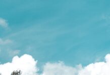 Historic buildings by the river in Luxembourg with autumn trees and a bright sky