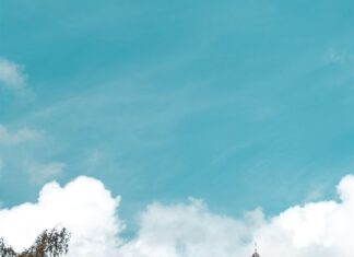 Historic buildings by the river in Luxembourg with autumn trees and a bright sky