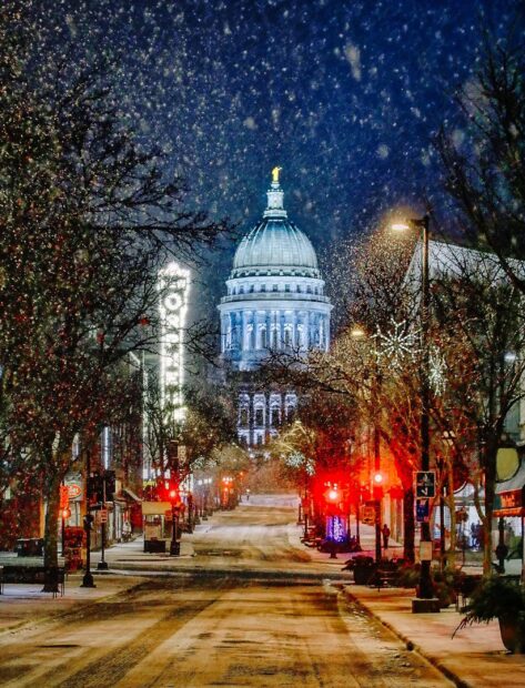 Snow falling on the street leading to the Madison Wisconsin Capitol building at night