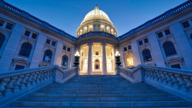 The impressive capitol building in Madison Wisconsin at dusk with illuminated columns and stairway