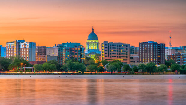 The Madison cityscape at sunset featuring the Wisconsin state capitol building and waterfront view