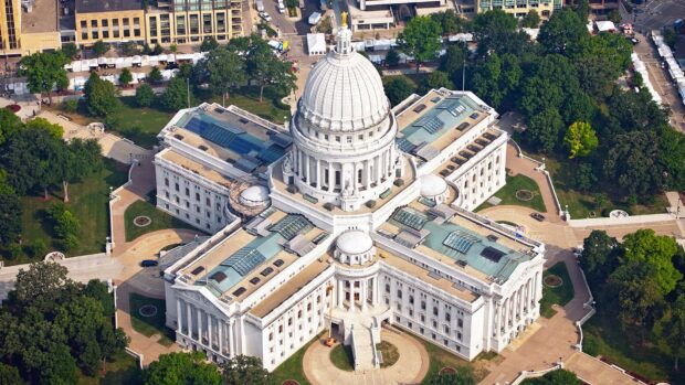 The Wisconsin State Capitol building in Madison Wisconsin under bright sunlight with surrounding greenery