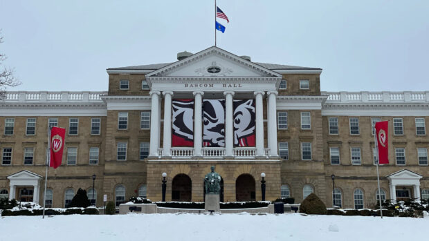 Bascom Hall in Madison Wisconsin with snow covered ground and flags flying