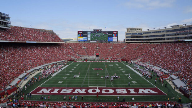 A crowded Madison Wisconsin stadium filled with fans watching a football game on a clear day