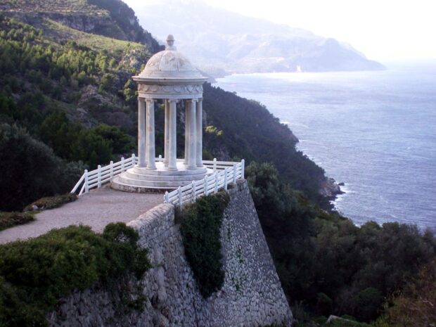 Ancient monument on a cliff in Mallorca surrounded by pine trees and sea view