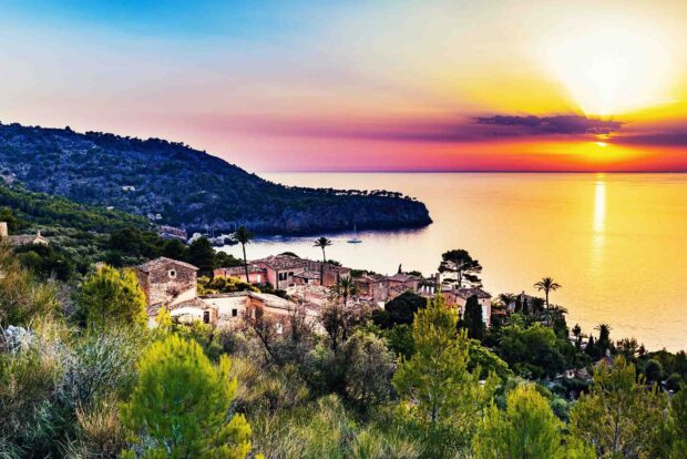Mediterranean coastline with Mallorca village and a colorful sunset sky