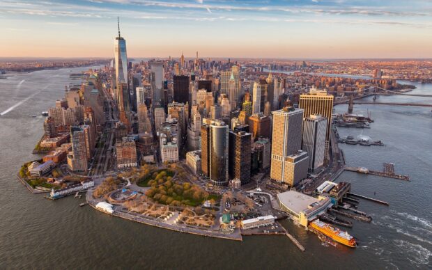 A stunning aerial view of Manhattan with its iconic skyscrapers and waterfront in golden sunlight