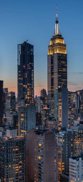Evening cityscape of Manhattan with illuminated skyscrapers and Empire State Building view