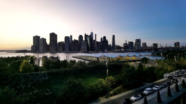 Manhattan skyline view at dusk with river and pier in the foreground