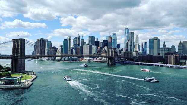 Manhattan skyline view with Manhattan and Brooklyn Bridge over river in clear day