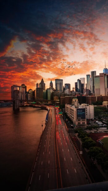Manhattan skyline with a busy highway and dramatic clouds during sunset in Manhattan