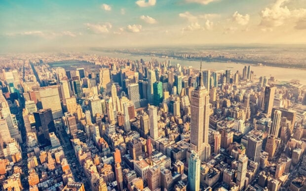 Aerial view of Manhattan cityscape with skyscrapers and river in the distance