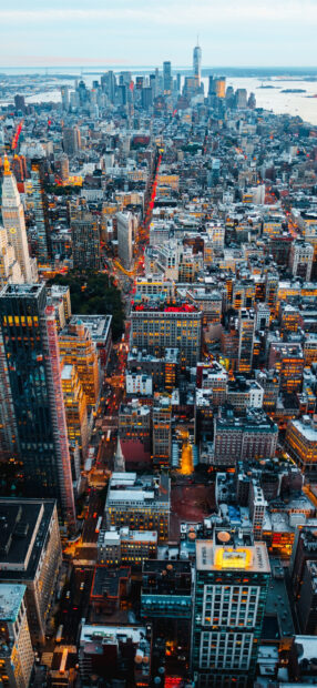 Aerial view of Manhattan cityscape with busy streets and illuminated buildings at dusk