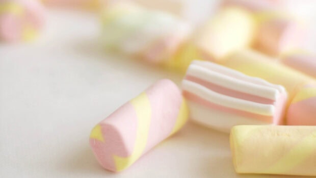 Soft pastel marshmallow with pink and yellow stripes on white surface