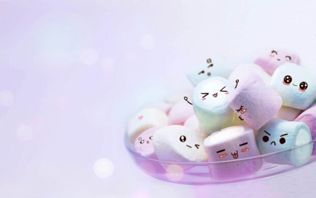 Cute marshmallow characters with different facial expressions in a clear bowl