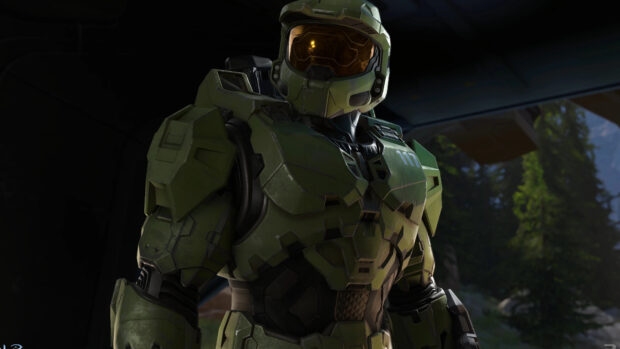 Master Chief in green armored suit standing inside a vehicle with trees visible outside