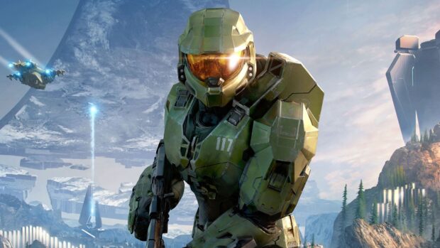 Master Chief in green armor standing in a futuristic snowy landscape with mountains and structures visible