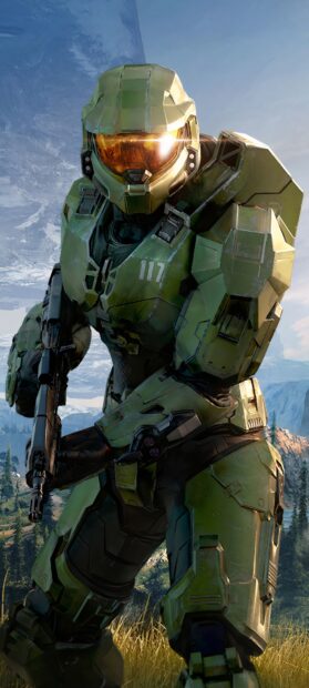 Master Chief standing in green armor holding a weapon in a scenic outdoor environment