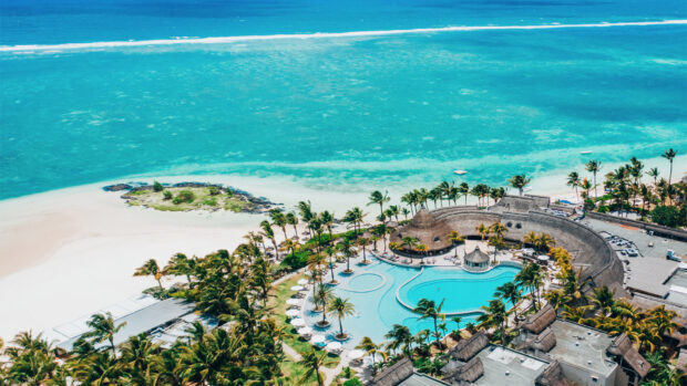 Aerial view of turquoise ocean and tropical island in Mauritius with palm trees and resorts
