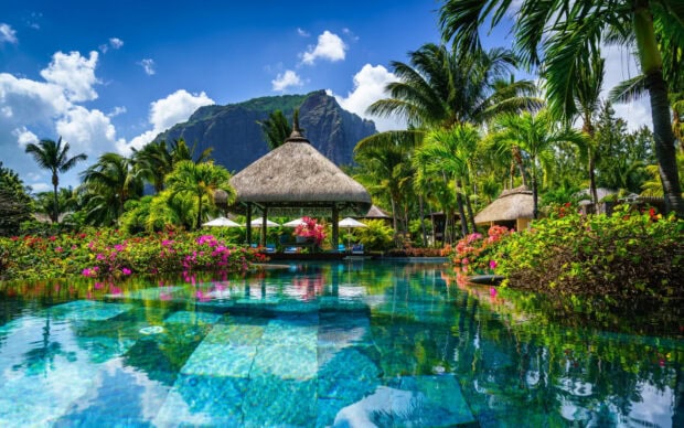 Tropical Mauritius Island resort with pool and palm trees under blue sky