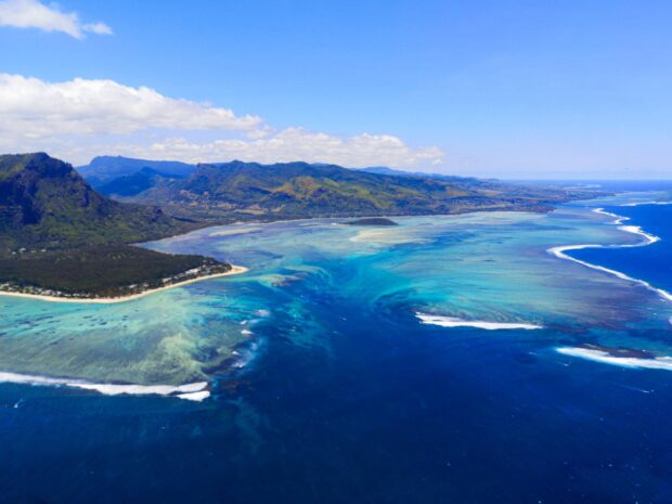 Aerial view of Mauritius Island coastline with turquoise waters and lush green mountains