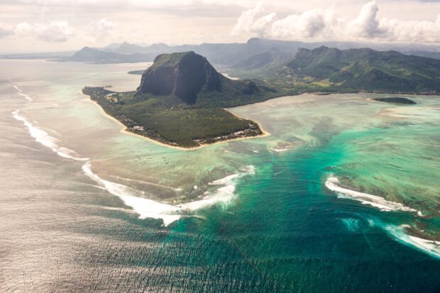 Aerial view of Mauritius Island showing lush green mountains and turquoise waters