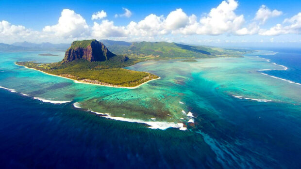 Aerial view of Mauritius Island showing vibrant waters and lush green landscape with clear skies