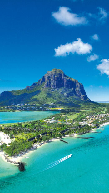 Clear turquoise waters surround Mauritius Island with a motorboat near the shore