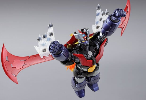 A detailed Mazinger Z robot figure flying with large red wings and armored fists raised up