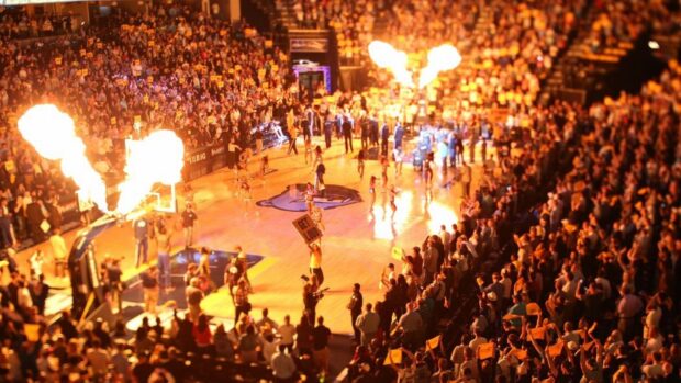 A Memphis Grizzlies basketball game with fans and dancers on the court before the match