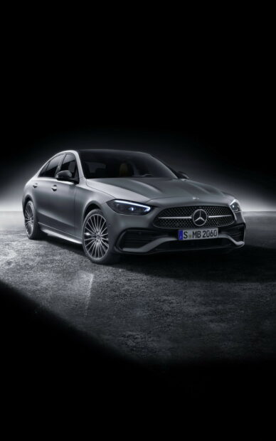 A sleek silver Mercedes Benz sedan showcased on a dark textured surface