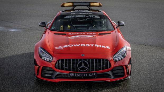 Red Mercedes Benz safety car with AMG logo and CrowdStrike branding on the hood