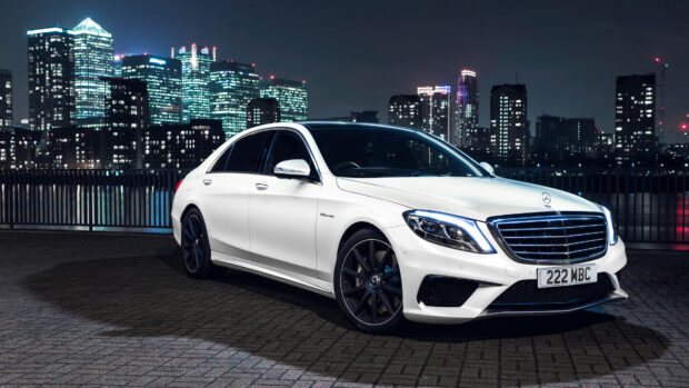 White Mercedes Benz luxury car parked at night in a cityscape environment