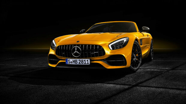 Yellow Mercedes Benz car showcasing sleek design and luxury features on dark background