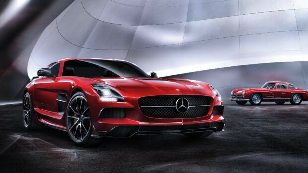 A red Mercedes Benz car parked in a modern setting with another classic Mercedes Benz car in the background